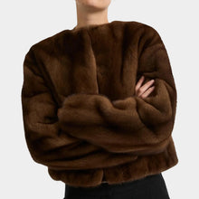 Brown fluffy sweater worn by a person on a plain background