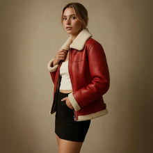 Woman wearing a red leather jacket with white fur lining against a beige background
